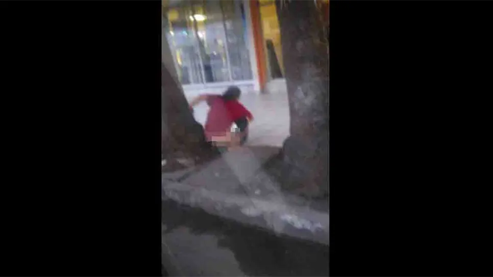 Un indigente realizando sus necesidades en plena banqueta.