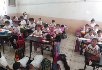 En el suelo toman clases niños de escuela primaria