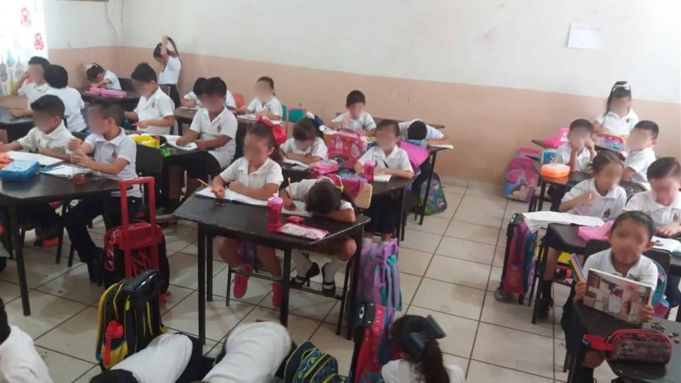 En el suelo toman clases niños de escuela primaria