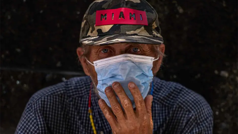 Un hombre viste una máscara mientras observa la calle, en la ciudad de Miami, Florida. EFE/Giorgio Viera/Archivo