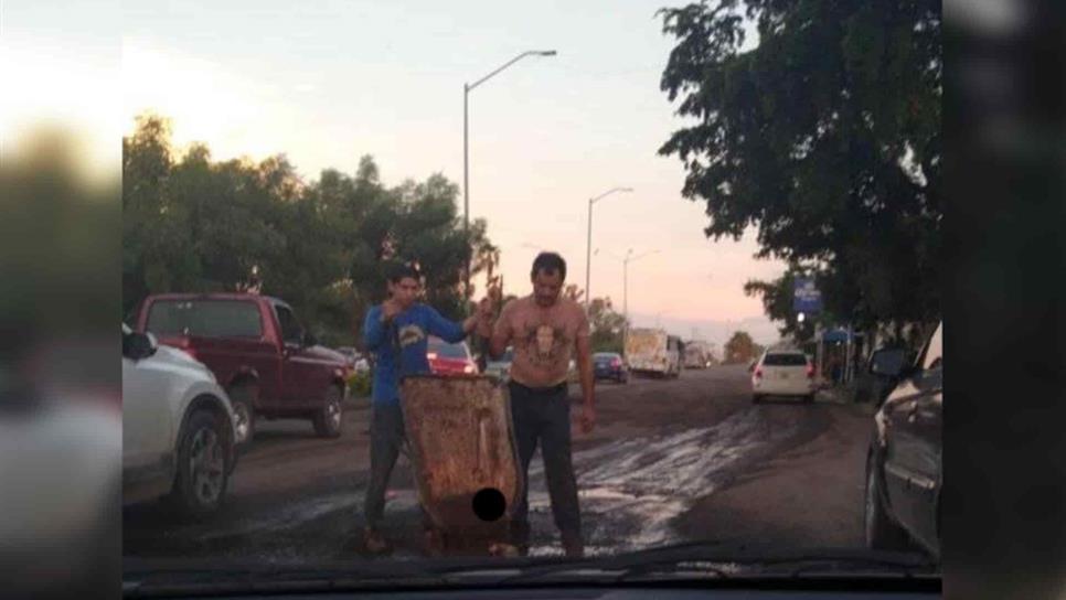 Jimmy y sus trabajadores toman la pala para tapar los baches