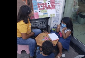 ¡Admirable!, mujer da clases a su hija en una banqueta de Navolato, mientras trabaja