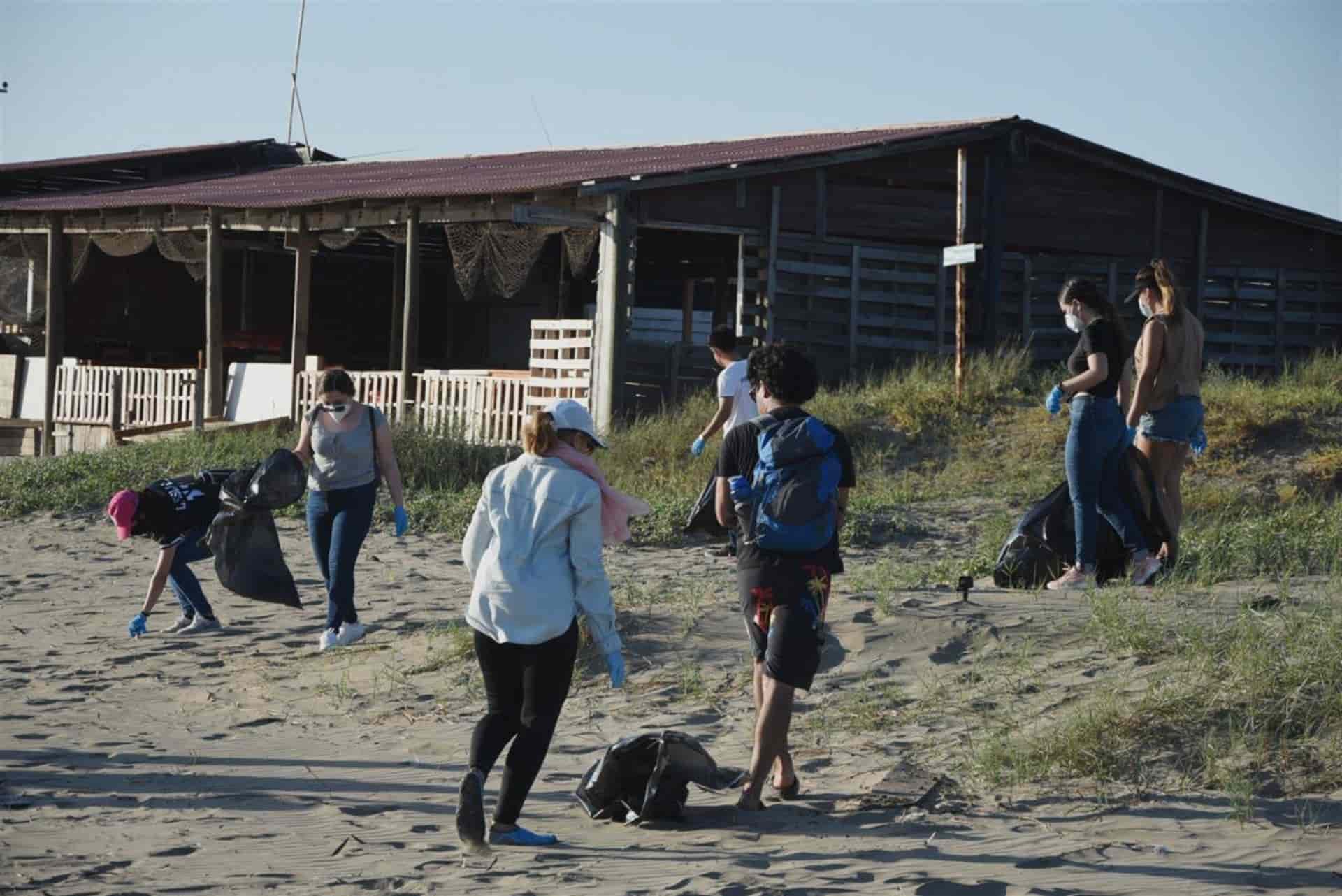 Jóvenes voluntarios de asociaciones estudiantiles limpian la playa de El Maviri