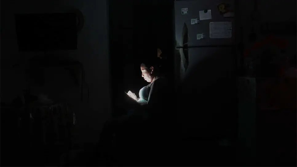 Una mujer observa su celular durante un apagón en el balneario de Cancún en el estado de Quintana Roo (México). EFE/Alosnso Cupul/Archivo