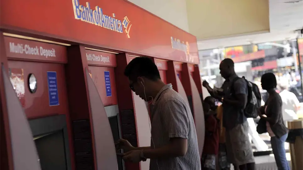 Un hombre saca dinero de un cajero automático en una sucursal del Bank of America en Times Square, Nueva York. EFE/Andrew Gombert/Archivo