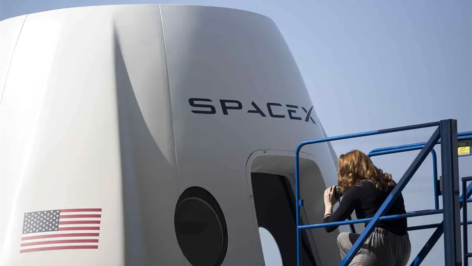 Una periodista toma fotos del exterior de una cápsula espacial de la empresa SpaceX en un enorme hangar de SpaceX situado en la ciudad de Hawthorne (EE.UU). EFE/Armando Arorizo/Archivo