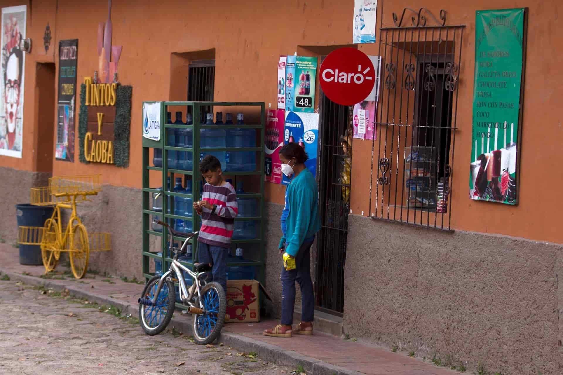 Una mujer sale de comprar en una tienda de abastos hoy en el municipio de Santa Lucia (Honduras). EFE/Gustavo Amador