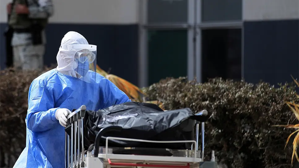 Un paramédico traslada a una persona fallecida por la covid-19, hoy en el Hospital General de Ciudad Juárez, en el estado de Chihuahua (México). EFE/Luis Torres