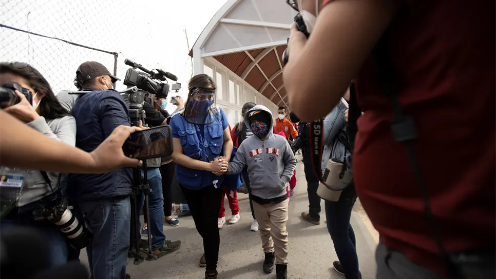 Una mujer y su hijo, solicitantes de asilo bajo el Protocolo de Protección a Migrantes, mejor cono conocido como MPP, ingresan este viernes a los Estados Unidos por el Cruce Internacional Santa Fe en El Paso, Texas. FOTO: EFE.