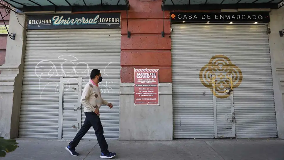 Un hombre camina frente a dos locales cerrados debido a la pandemia, en Ciudad de México. EFE/Sáshenka Gutiérrez/Archivo