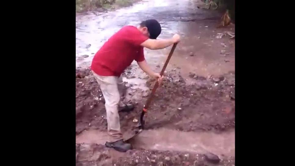 Con una pala hacen zanja para no inundarse en el Águila Azteca