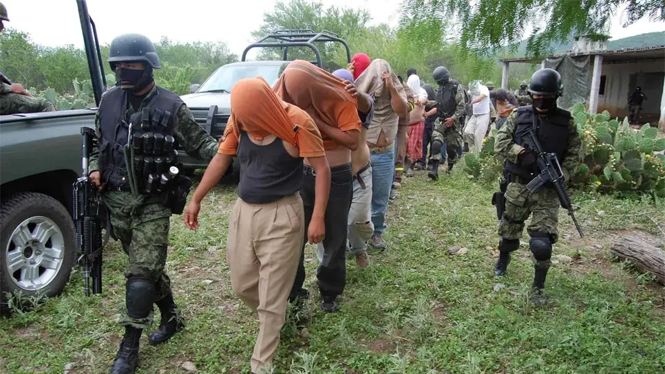 Fotografía de archivo en la que se observa a soldados del Ejército custodiar a 16 personas que habían sido secuestradas y que fueron encontrados encadenados. EFE/Juan Cedillo