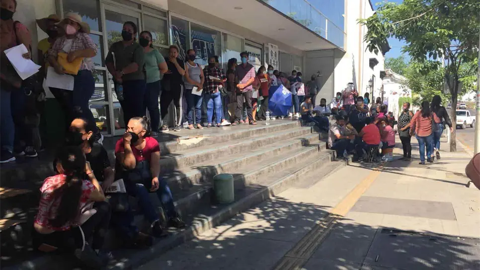 Ni el calor impide las largas filas para cobrar pago de becas en Culiacán