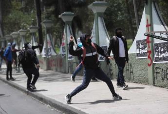 Familiares y amigos de normalistas de Ayotzinapa se enfrentan a policías en manifestación