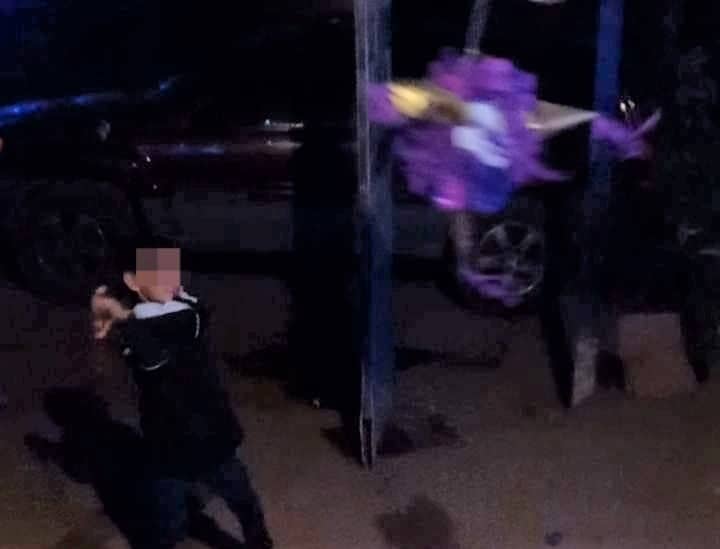 El niño Jared pegándole a una piñata durante los festejos.