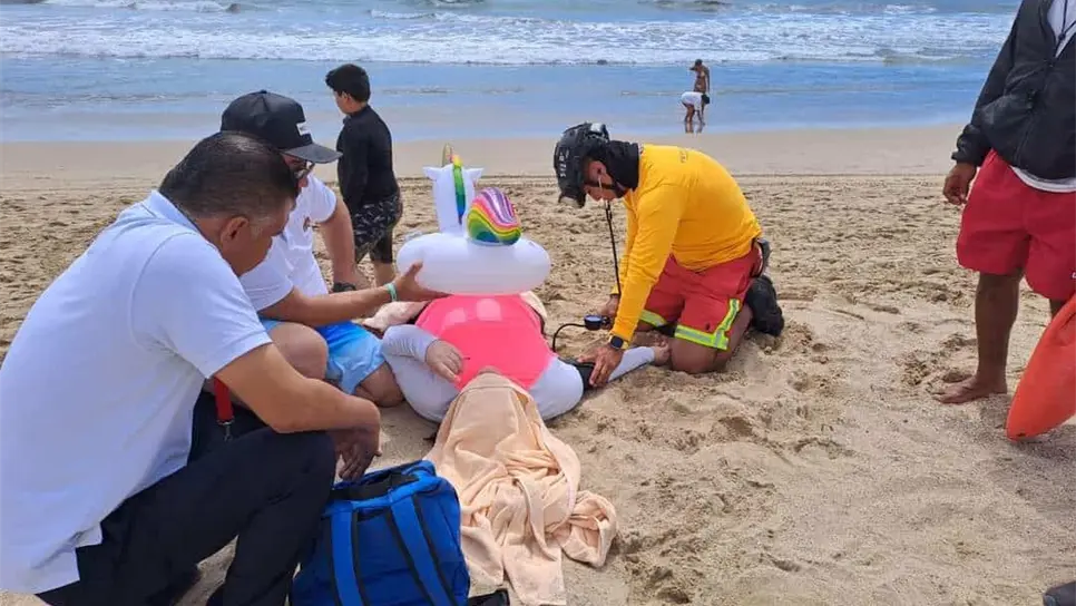 Rescatistas atienden a la turista que se desplomó por el calor.
