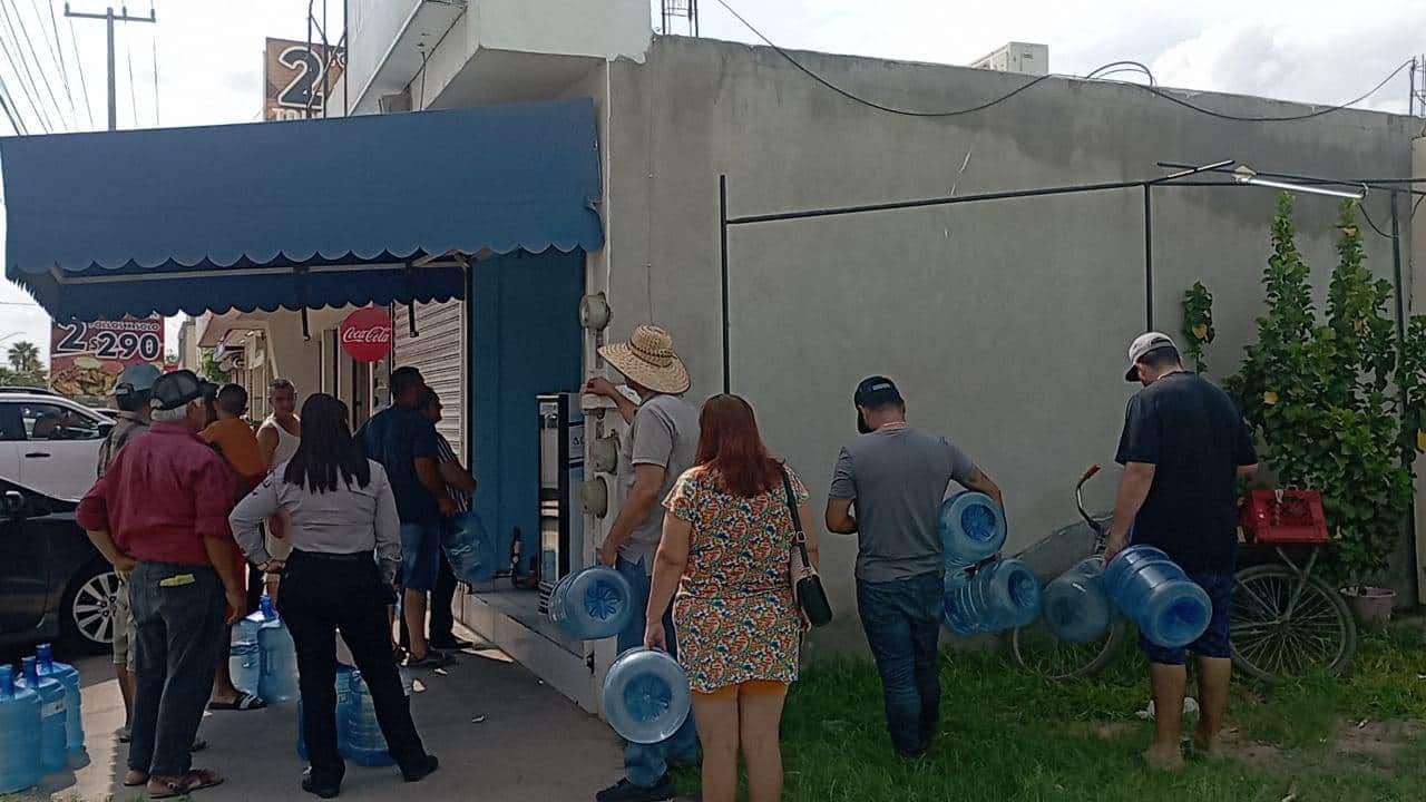 Mochitenses hacen fila para obtener un garrafón de agua.