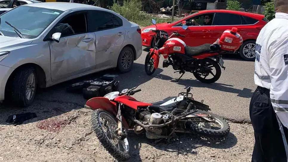 La moto quedó tirada a un lado del vehículo.