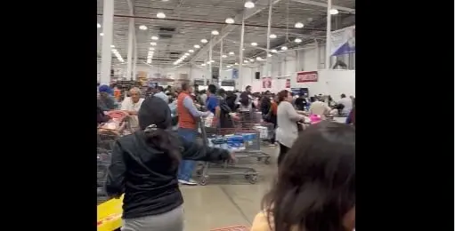 Cientos de personas hacen largas filas para pagar sus compras navideñas.