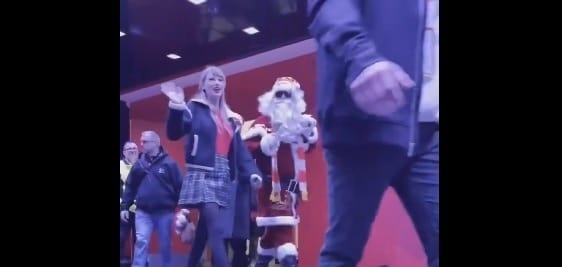 La cantante va rumbo a uno de los palcos acompañada por Santa Claus.