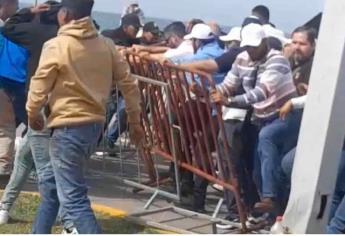 Manifestantes de la UAS derriban valla para acercarse a AMLO