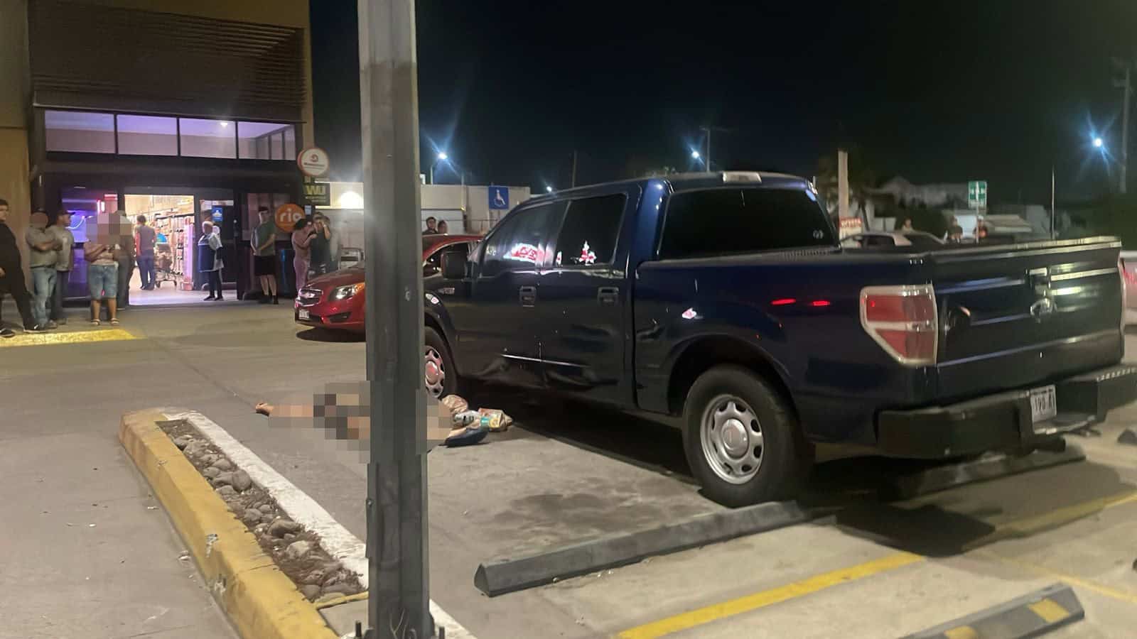 El cuerpo quedó a un costado de una camioneta.